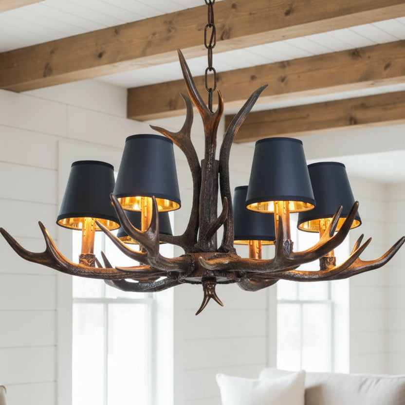 Chandelier with antler design and dark lampshades in a room setting.
