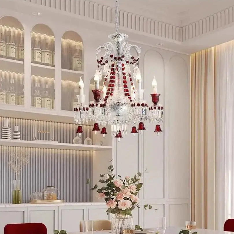 Luxurious chandelier in a dining room with floral arrangements and candles.