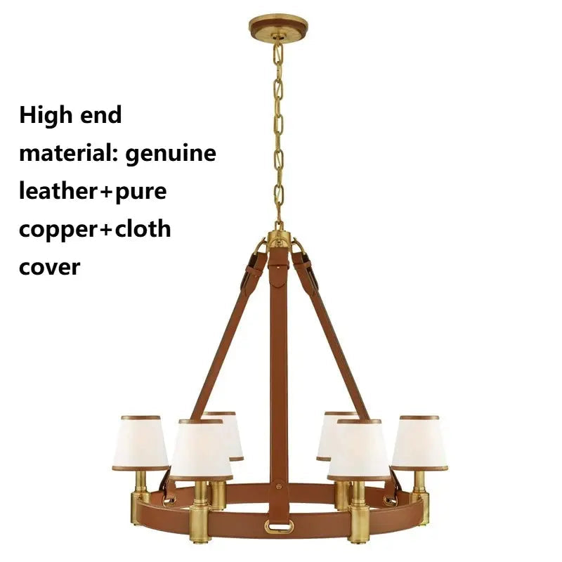 A six-light chandelier with a warm brass frame, leather-look brown straps, white drum shades, and brass hardware, shown on a white background with descriptive text in English and Arabic about materials.