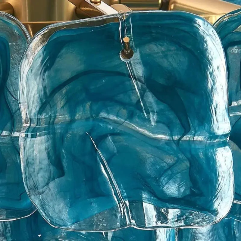 Blue glass bowl with water droplets on a reflective surface