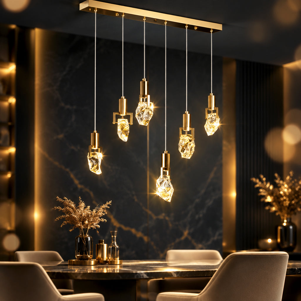 Six-light linear crystal chandelier with staggered drops and a gold-toned ceiling bar above a dining table.